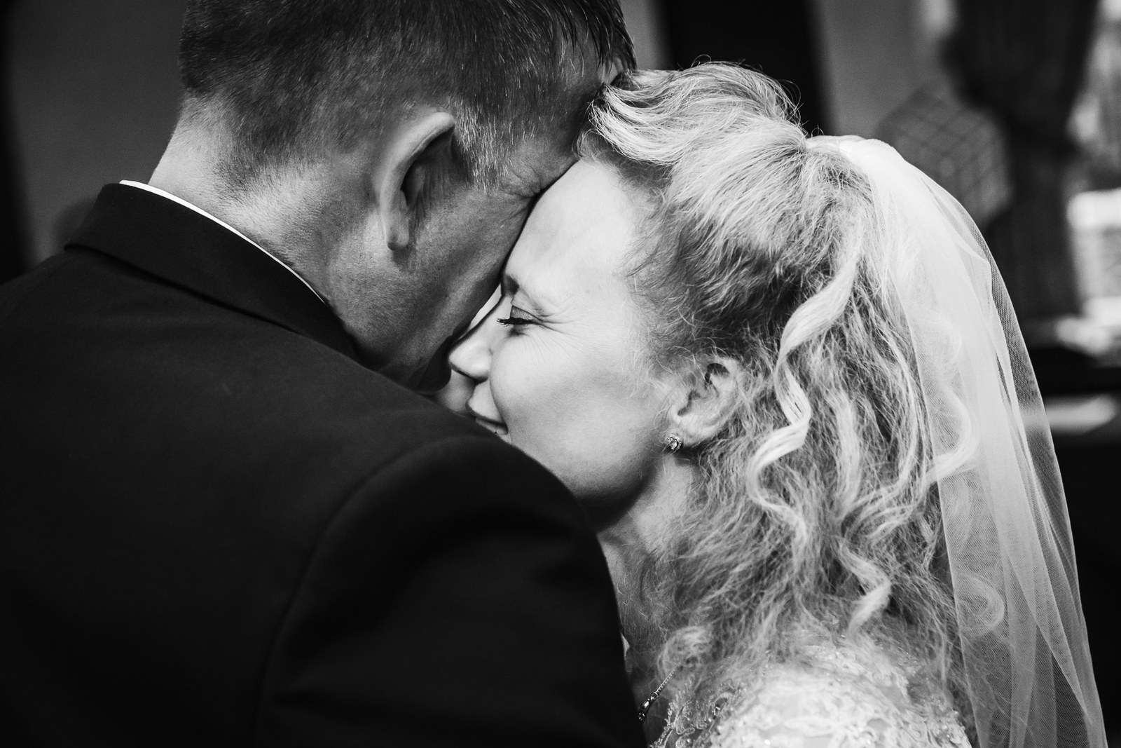 Black-and-white of the couple's first dance, foreheads gently together