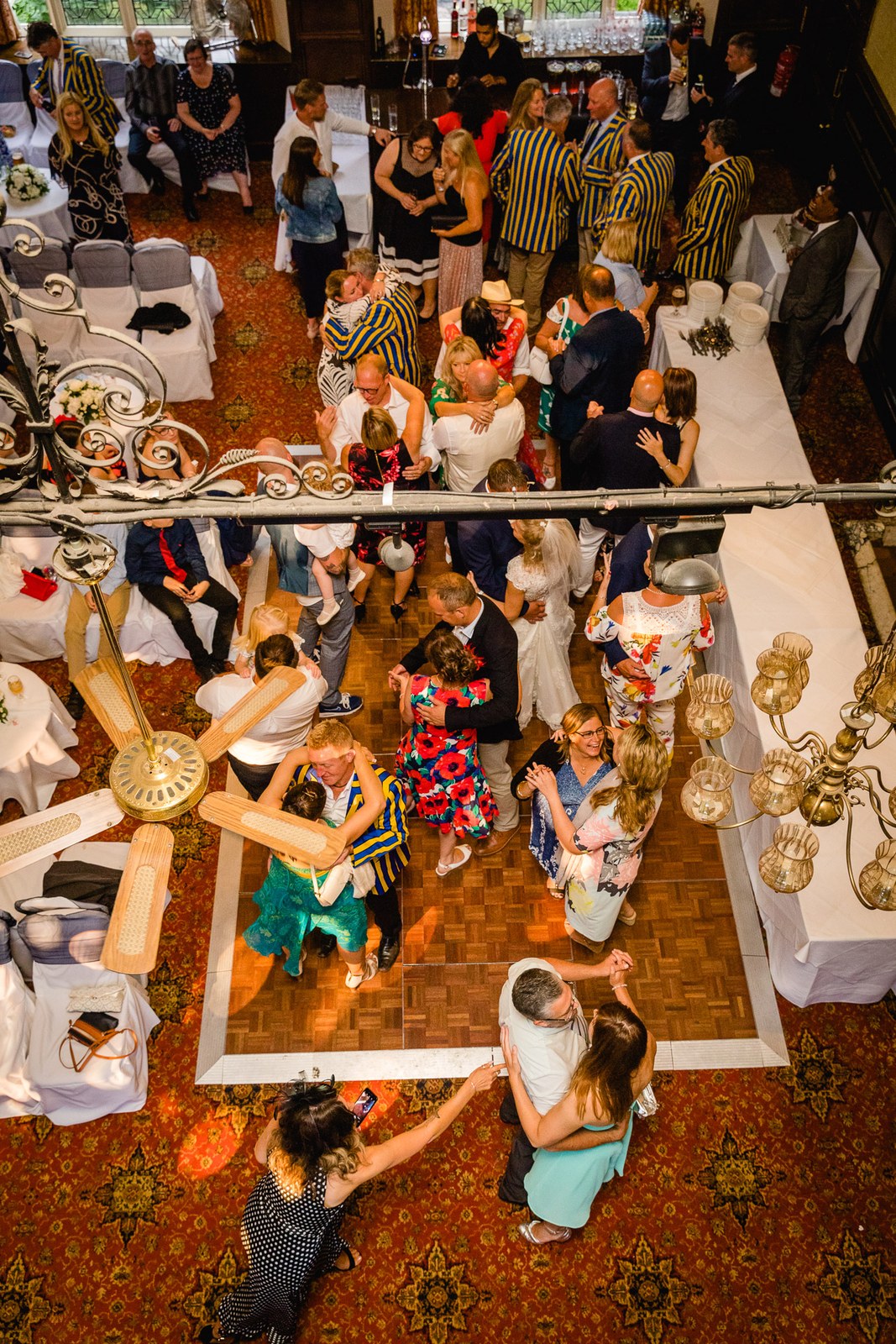 Overhead view of guests dancing on the patterned reception floor at Grim's Dyke Hotel