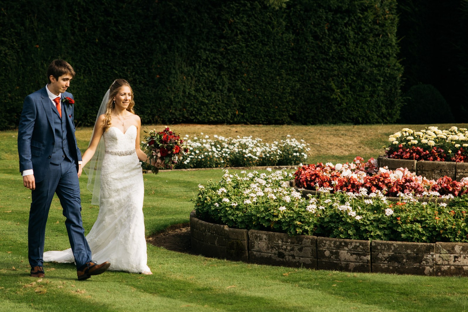 The couple strolling past the flower borders in the gardens of Grittleton House