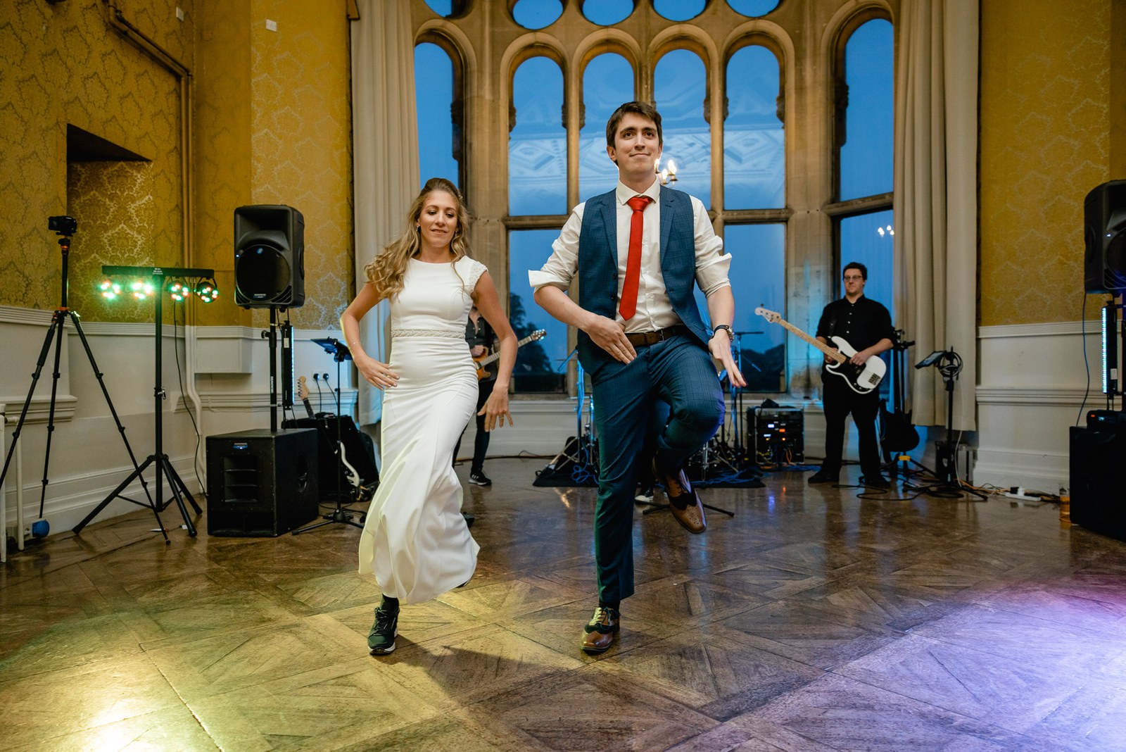 The couple dancing on the floor as the band plays behind them