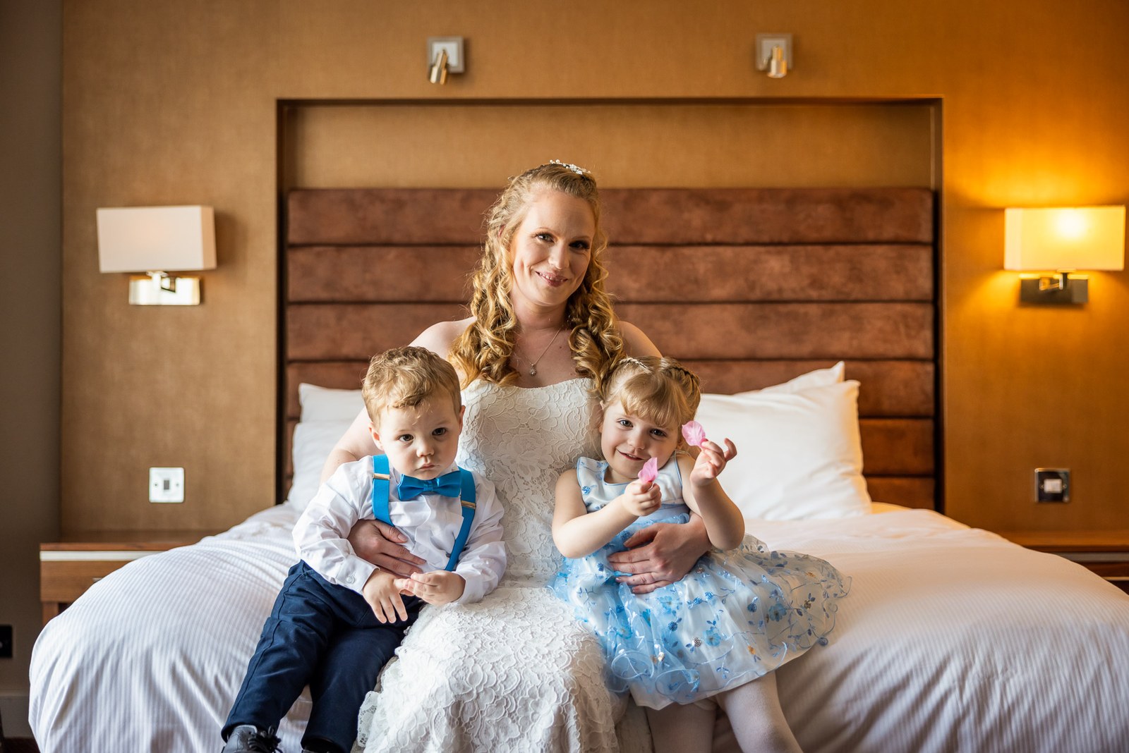 The bride with two children on the bed of a guest room at The Hampshire Court Hotel
