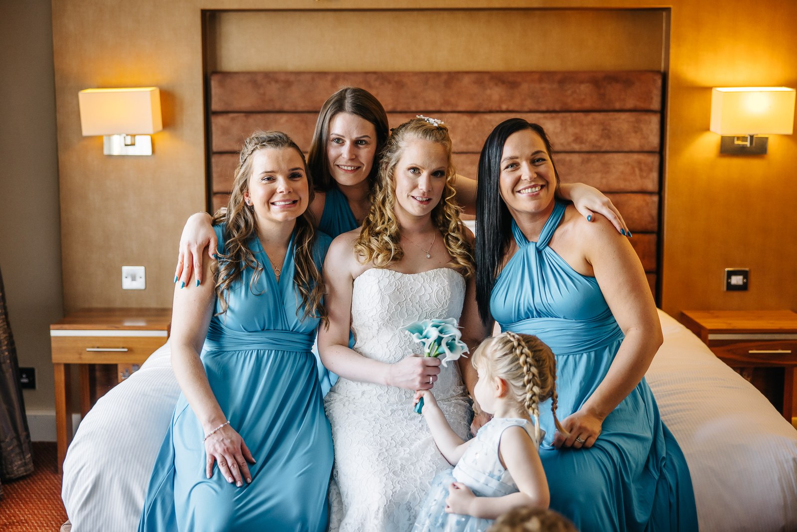 The bride seated with her bridesmaids in teal dresses