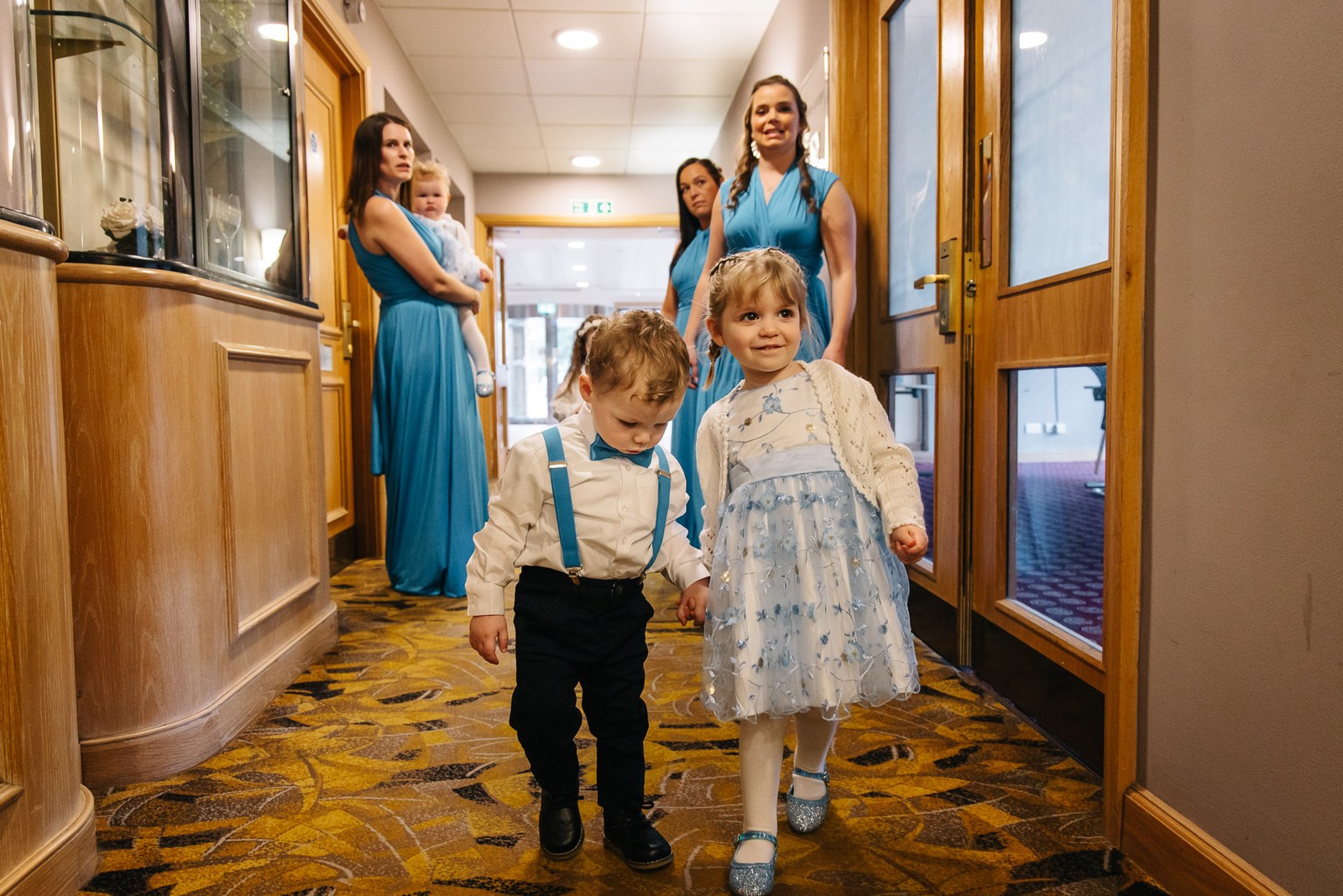 Bridesmaids and children walking a corridor at The Hampshire Court Hotel