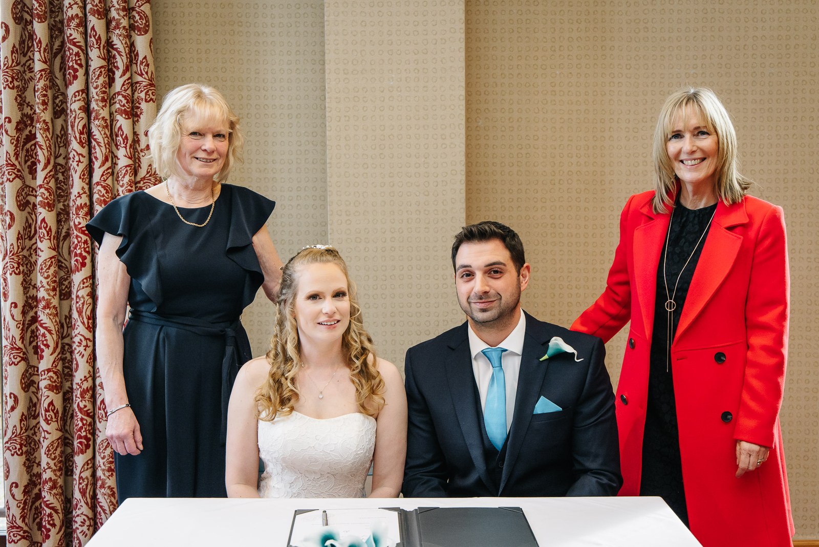 The couple with their mothers at the signing table after the ceremony