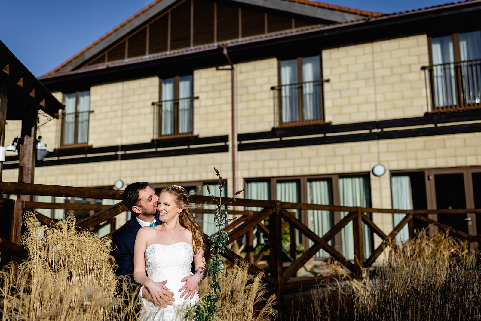 The couple kiss among the ornamental grasses in front of The Hampshire Court Hotel