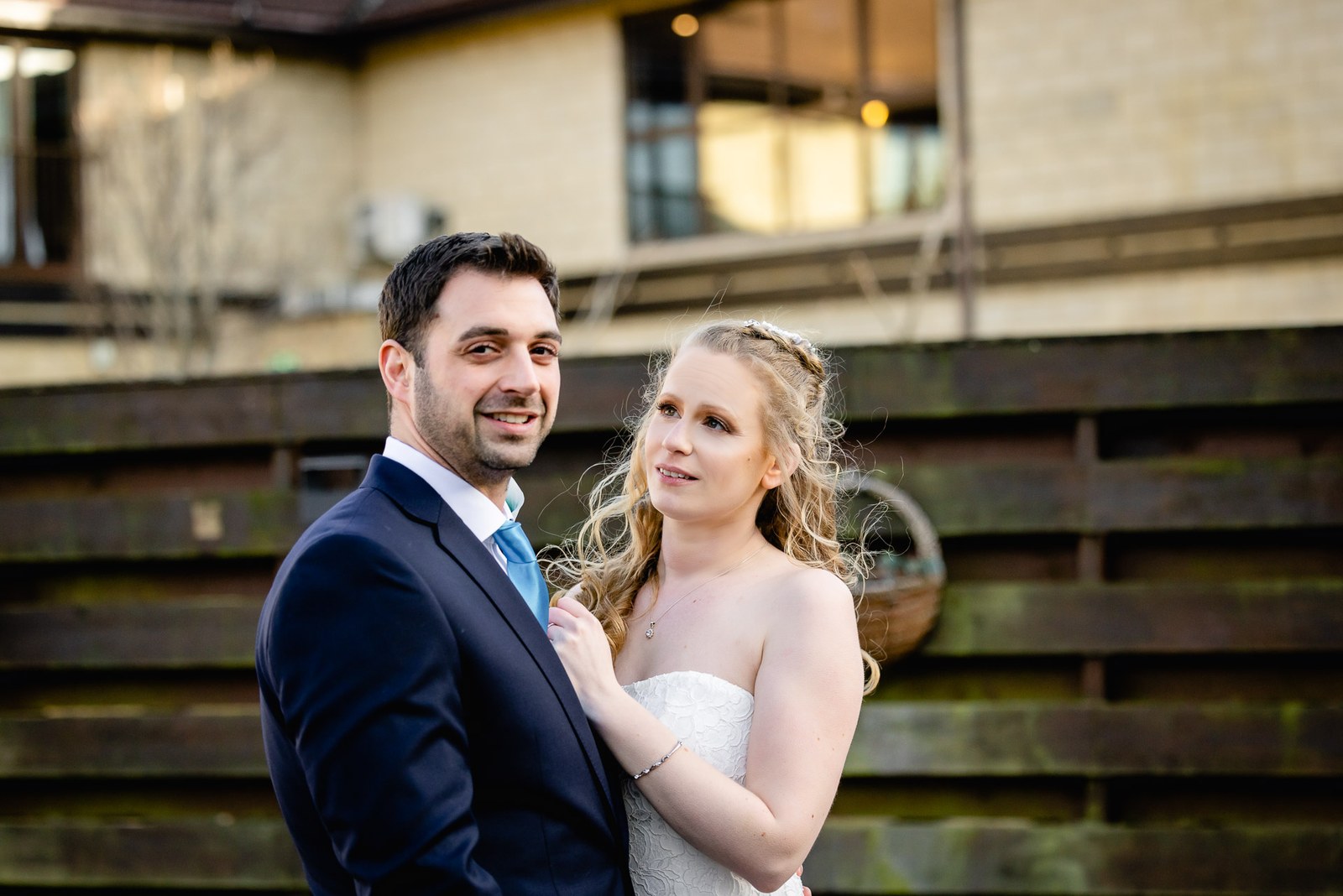 The couple embracing on the hotel's wooden terrace as evening falls