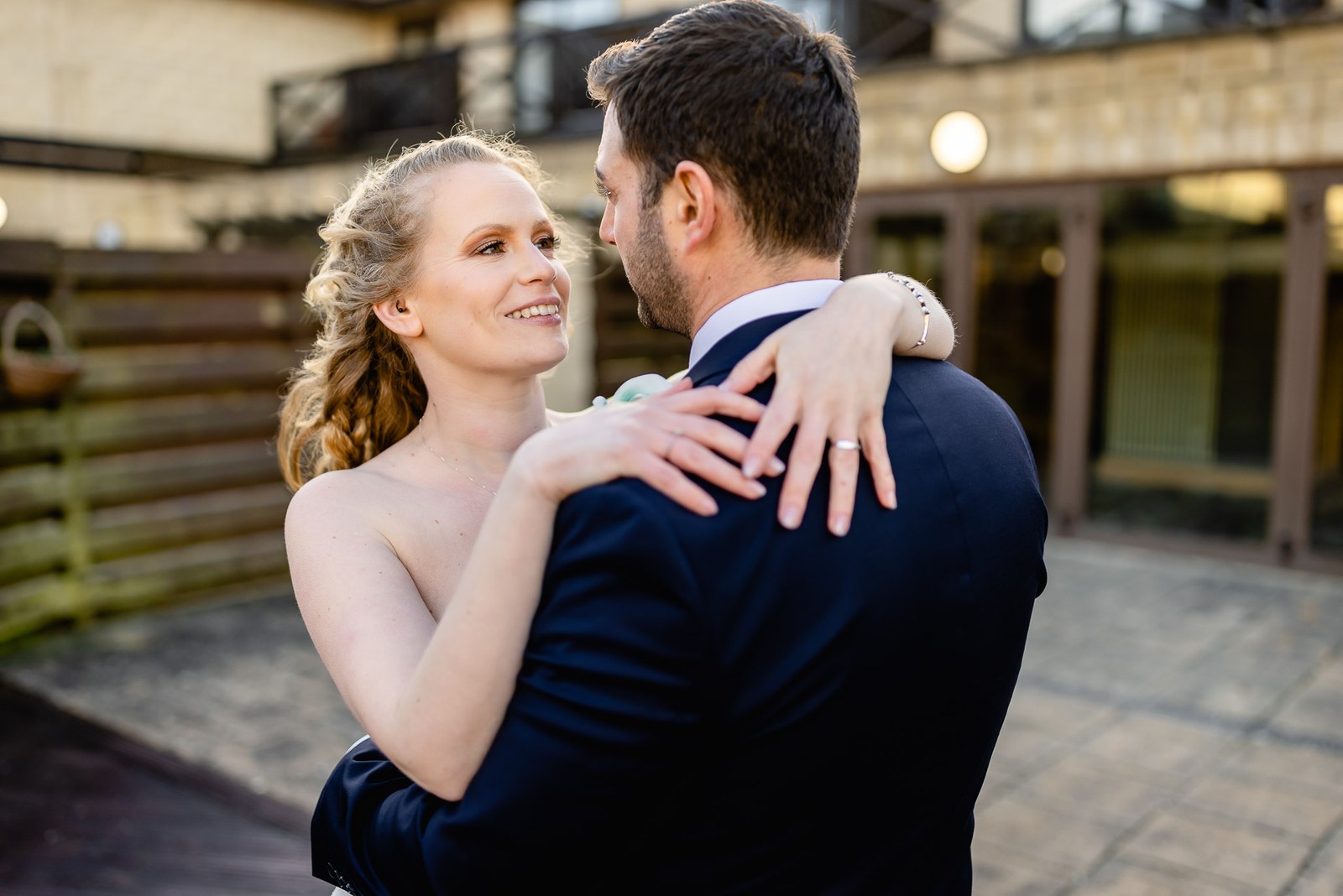 The couple embrace in the hotel courtyard as the light fades