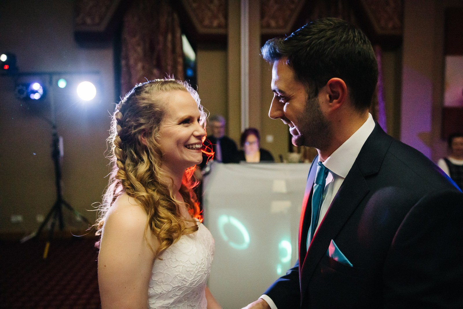 The bride and groom dancing beneath colourful disco lights