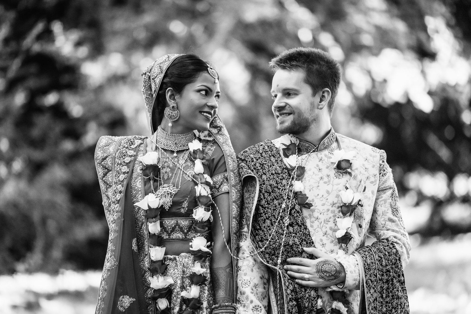 Black-and-white portrait of the couple gazing at each other outdoors