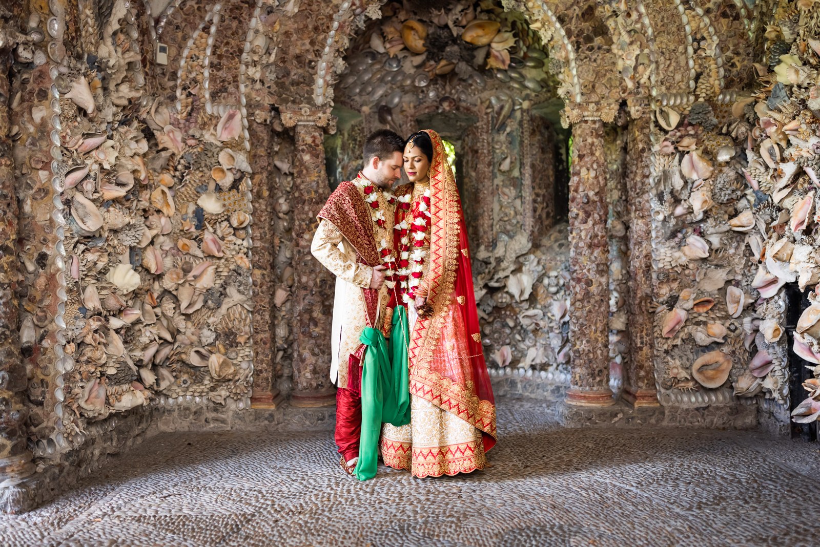 The couple framed within the shell-encrusted grotto at Hampton Court House