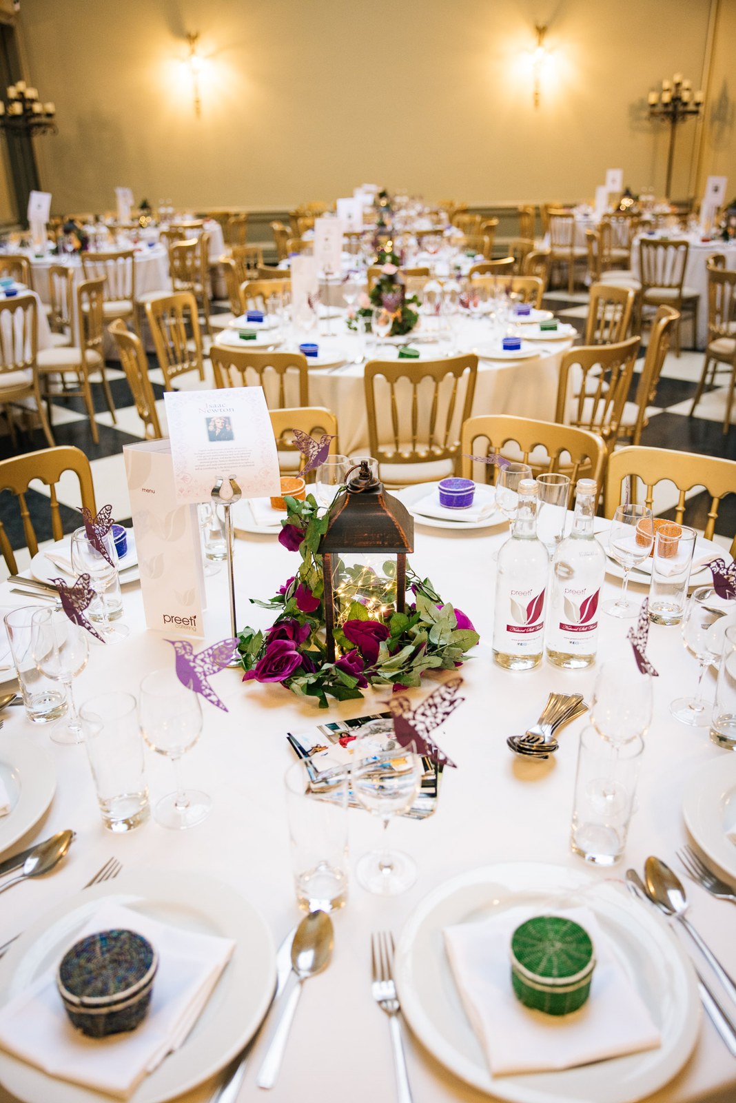 The reception laid with round tables and lantern centrepieces at Hampton Court House