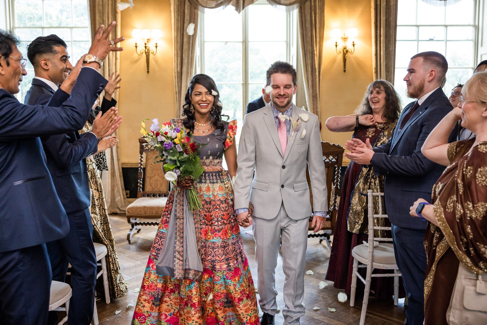 Confetti moment as the newlyweds walk the aisle to applauding guests