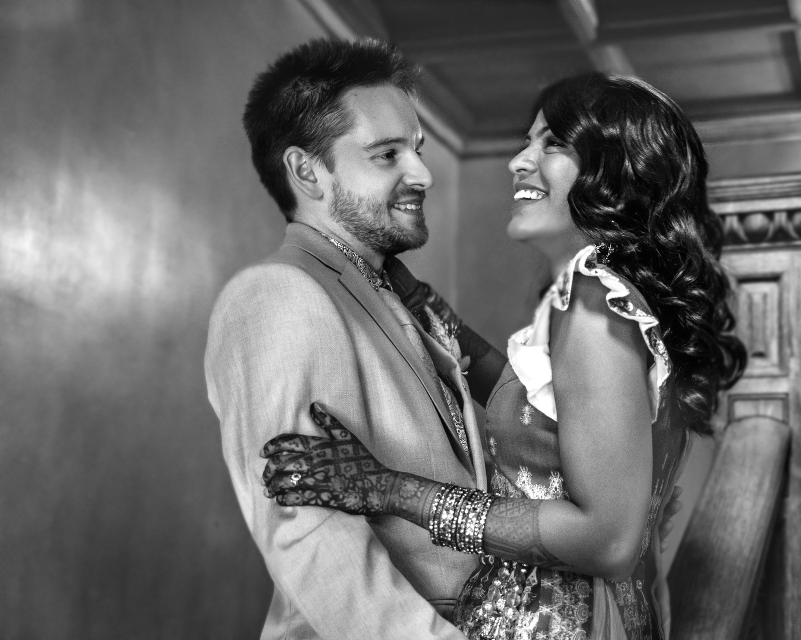 Black-and-white portrait of the couple in a close embrace indoors