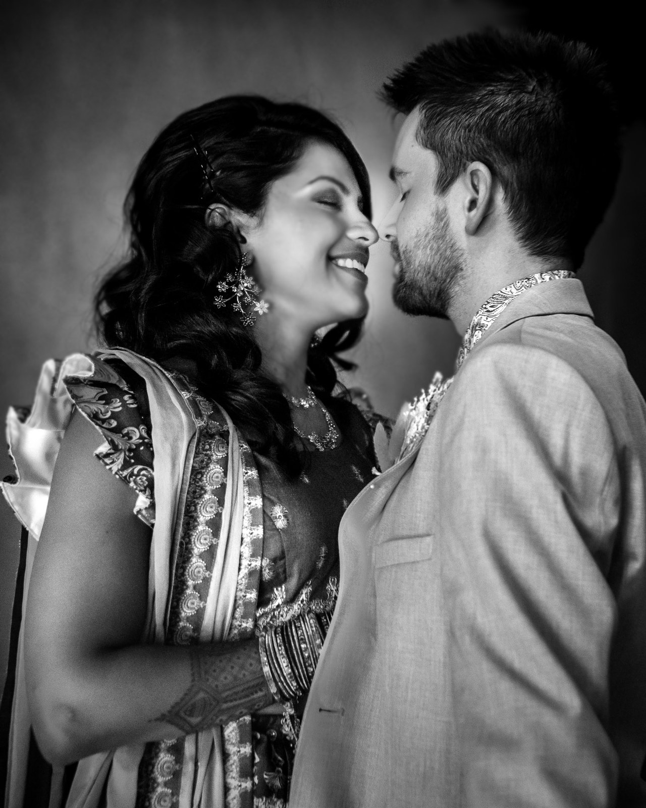 Black-and-white moment of the couple sharing a kiss