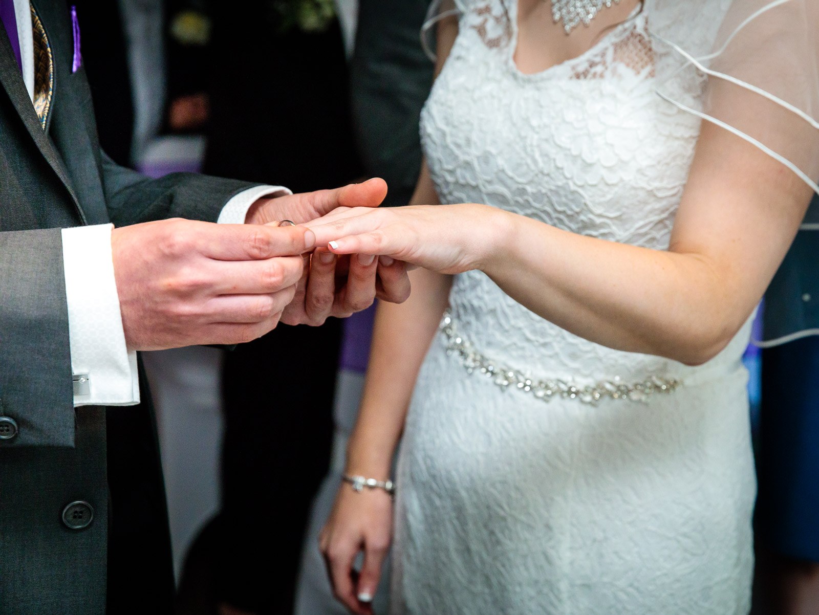 The groom sliding the ring onto the bride's finger during the ceremony