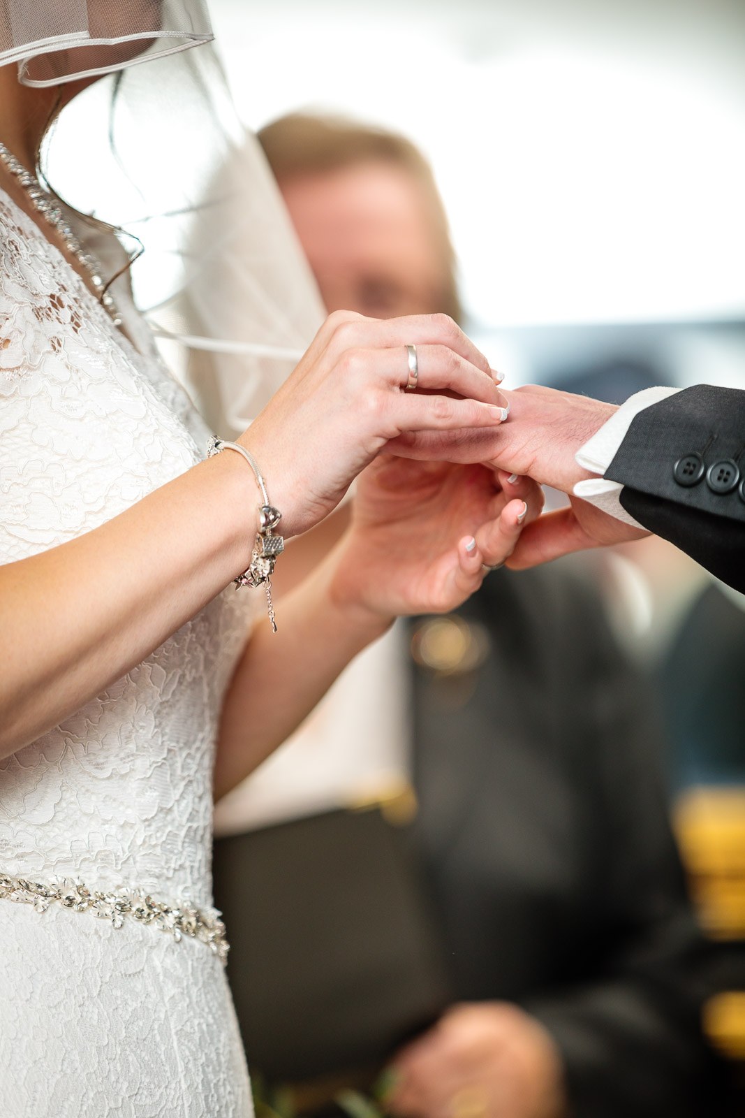 The bride placing the ring onto the groom's finger