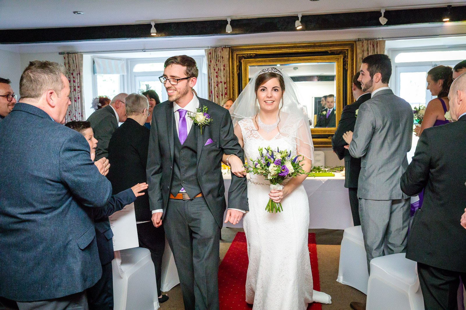 The newlyweds walking back down the aisle past their guests