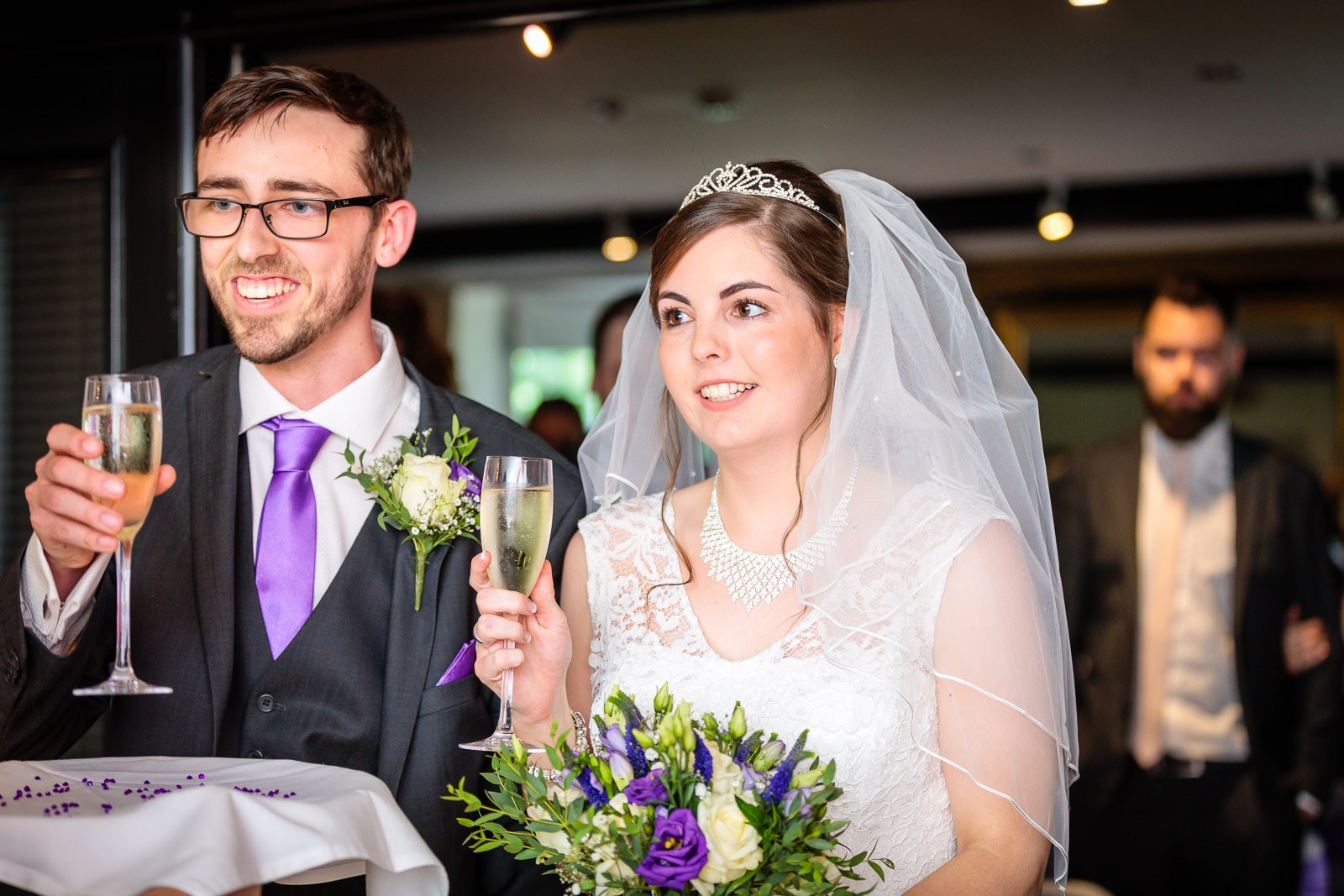 Bride and groom together with glasses of champagne after the ceremony