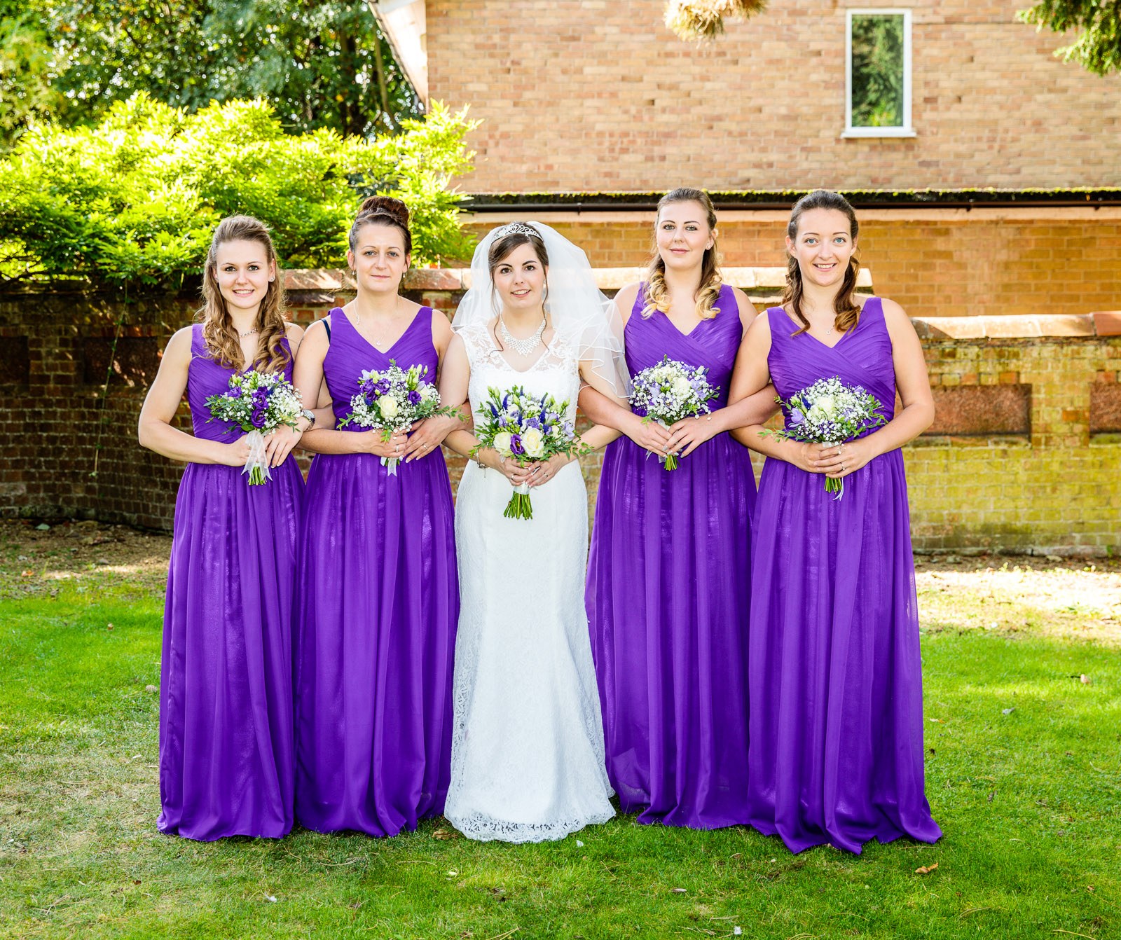 The bride with her four bridesmaids in purple on the lawn at Hawkwell House Hotel