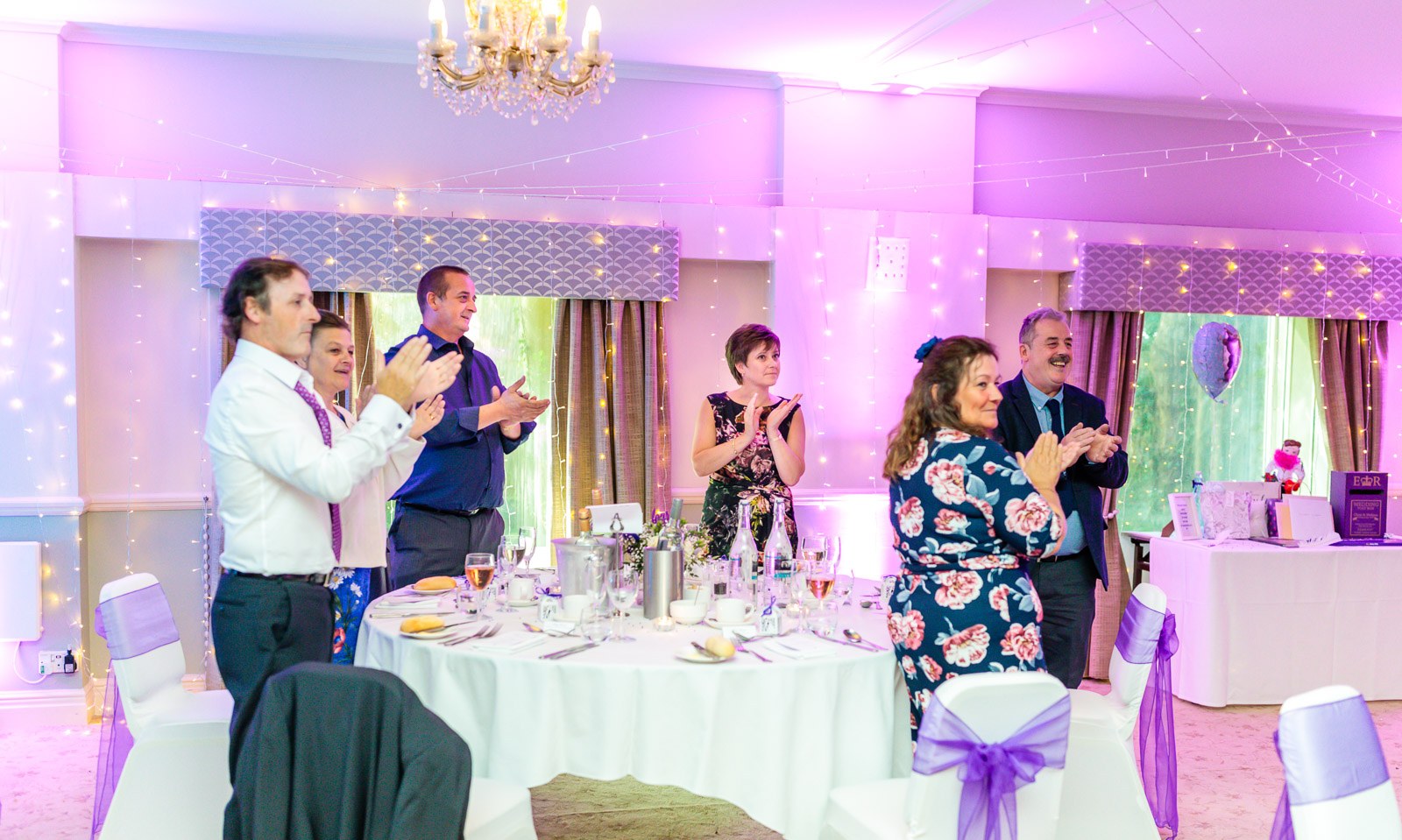 Guests on their feet applauding the newlyweds in the reception room