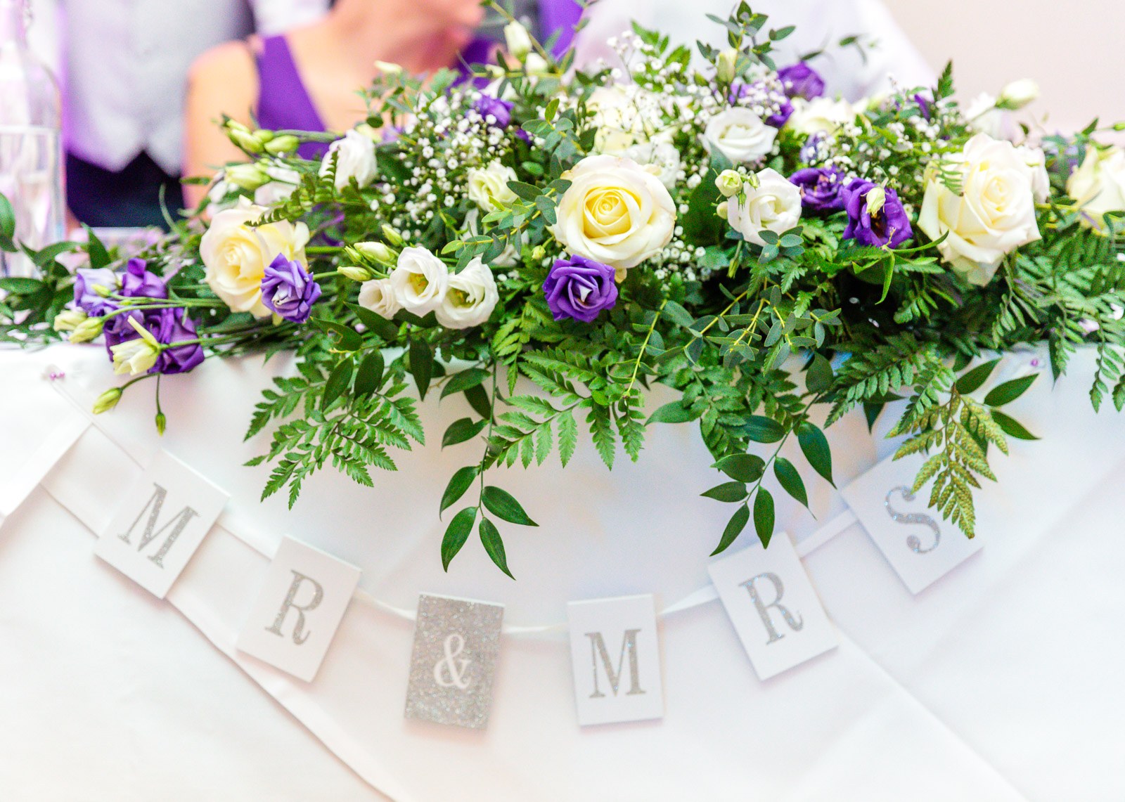 Close-up of the top-table flowers above a 'Mr & Mrs' bunting
