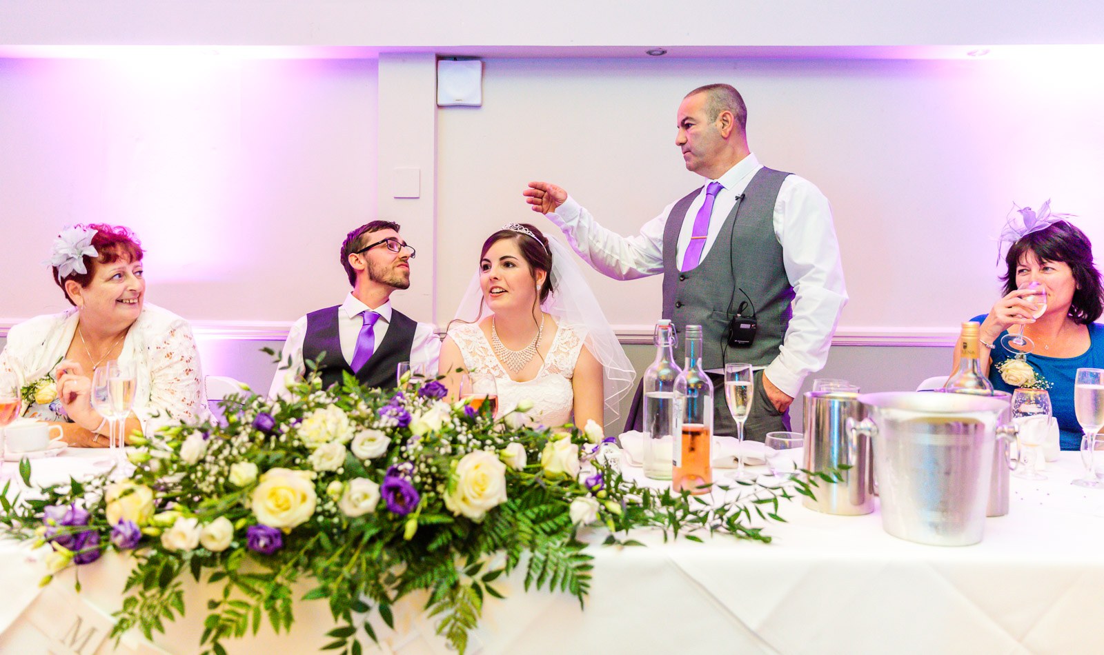 The father of the bride on his feet delivering a speech at the top table