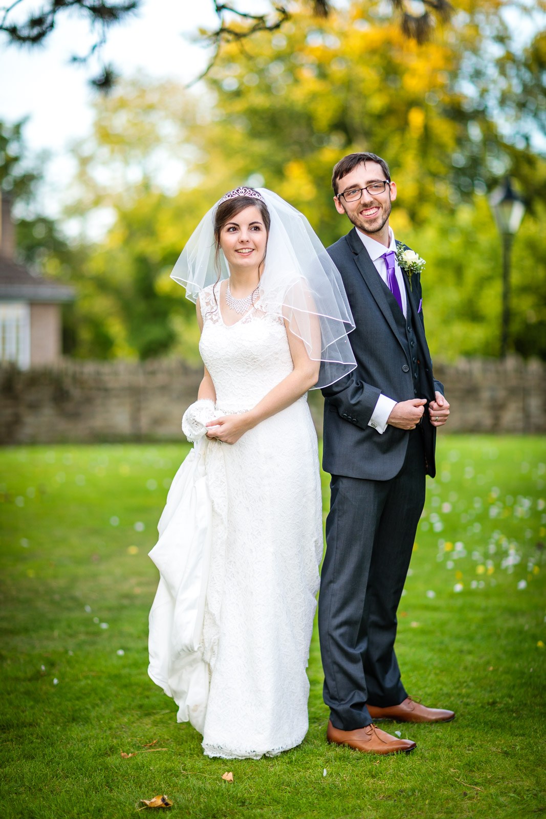 Portrait of the couple on the lawn among golden autumn trees