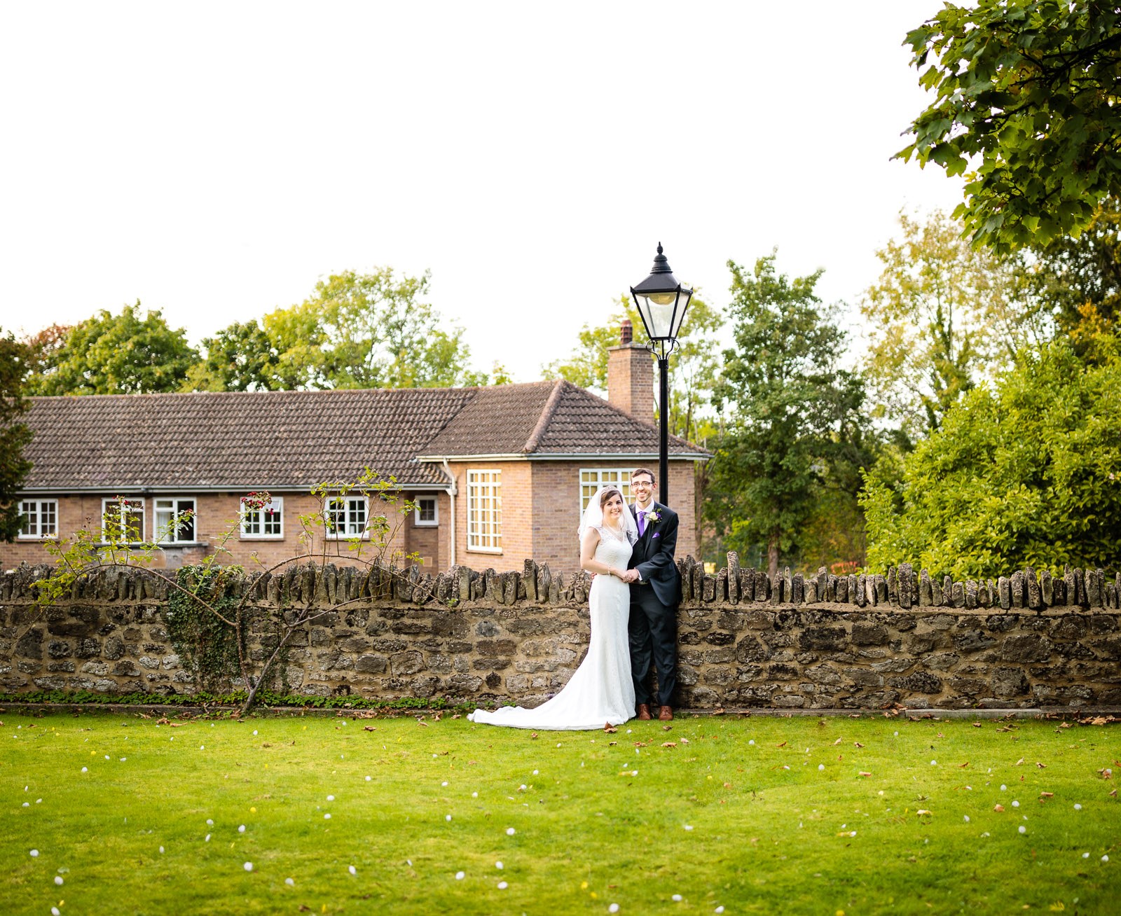 The couple small against the stone garden wall with the hotel behind