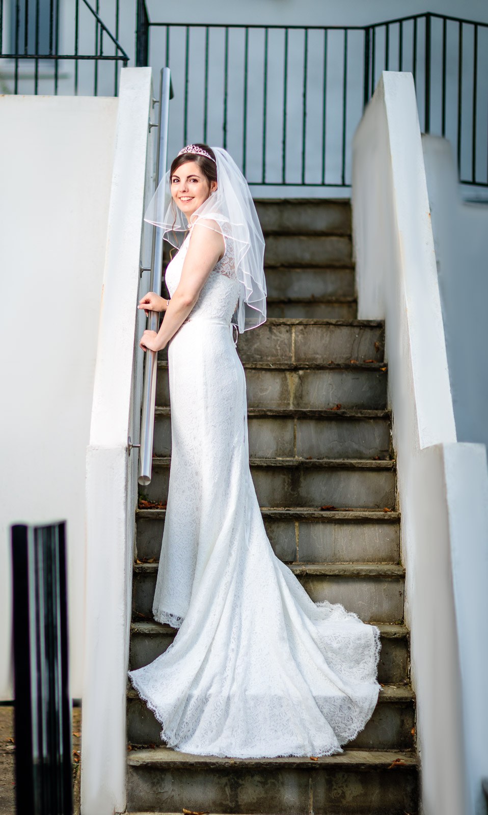 The bride pausing on the hotel's exterior staircase, veil trailing