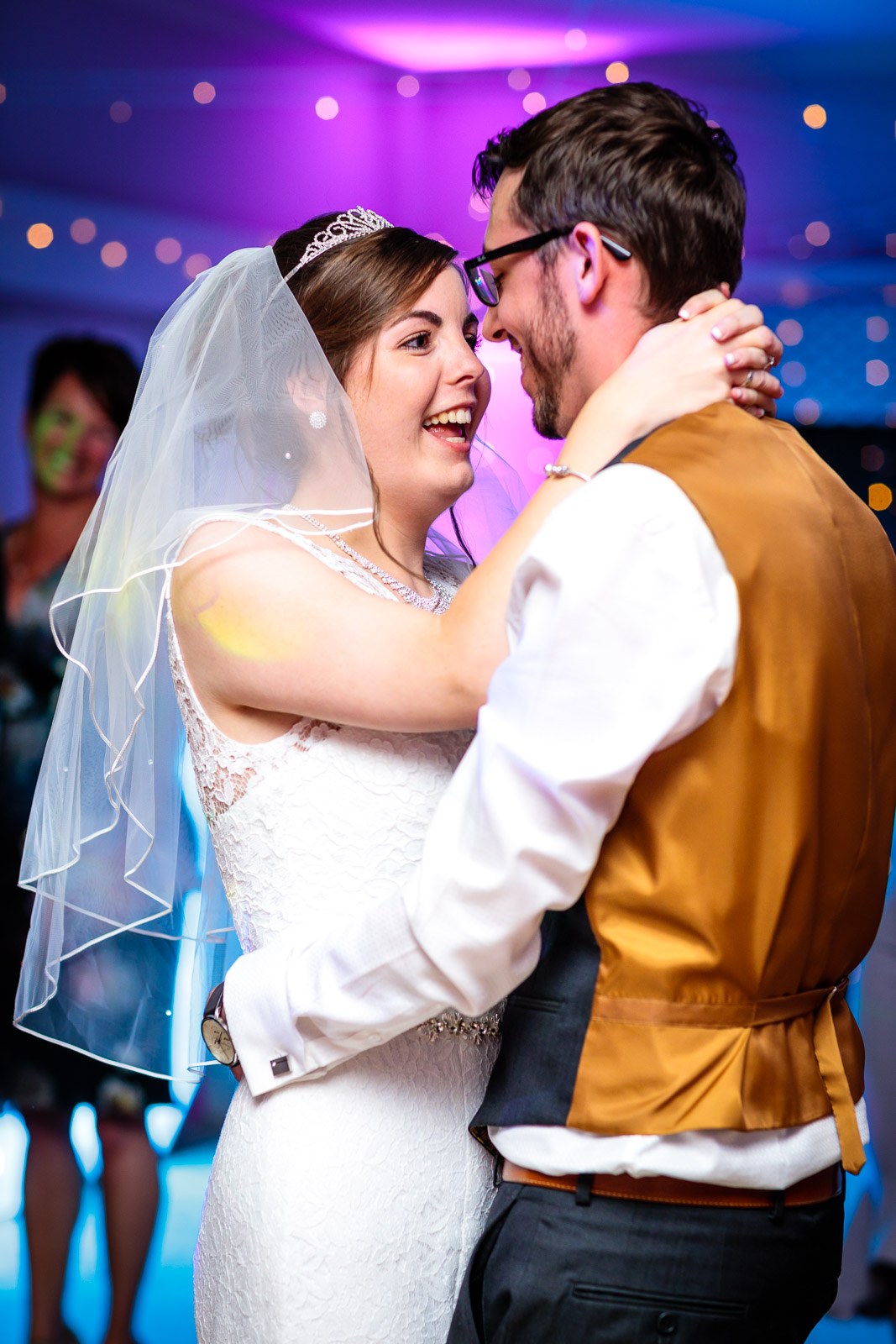 The first dance, the bride laughing as she looks into the groom's face