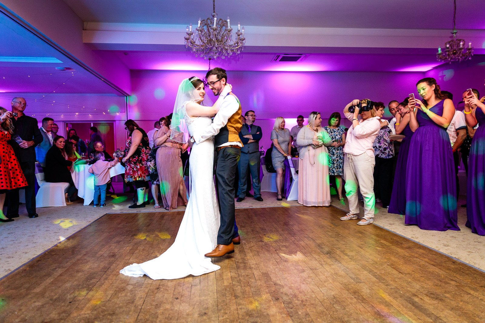 The couple's first dance beneath the chandelier as guests ring the floor at Hawkwell House Hotel