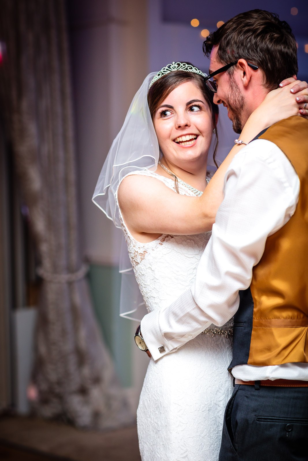 The bride glancing aside mid first dance under the disco lights