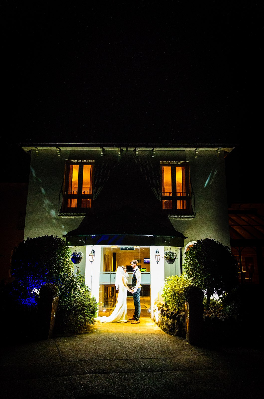 Hawkwell House Hotel at night, the couple lit in the glowing entrance