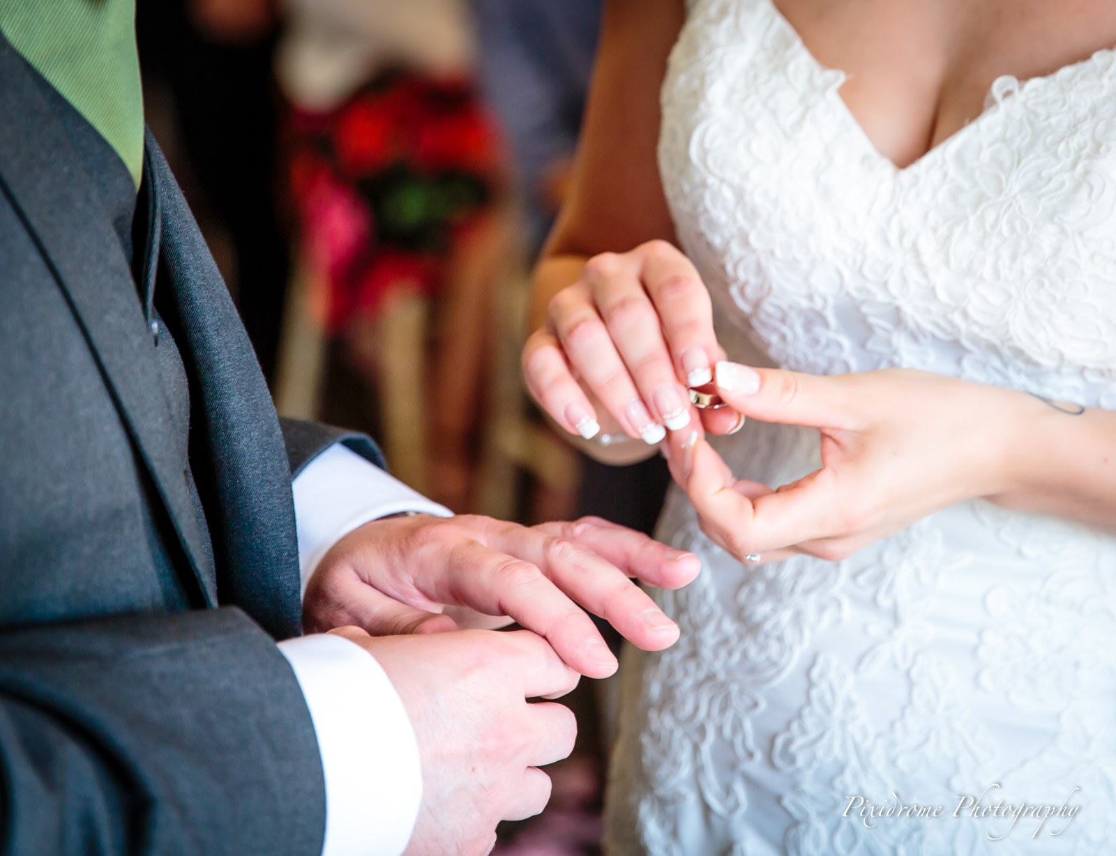 Close-up of the ring being placed on the groom's finger