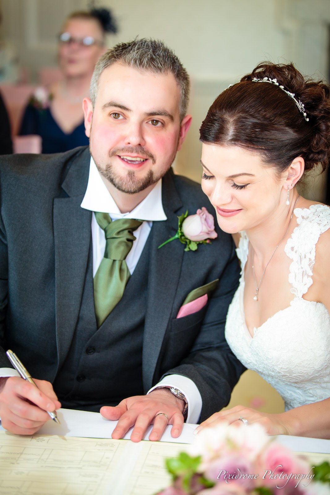 Bride and groom smiling together at the signing table