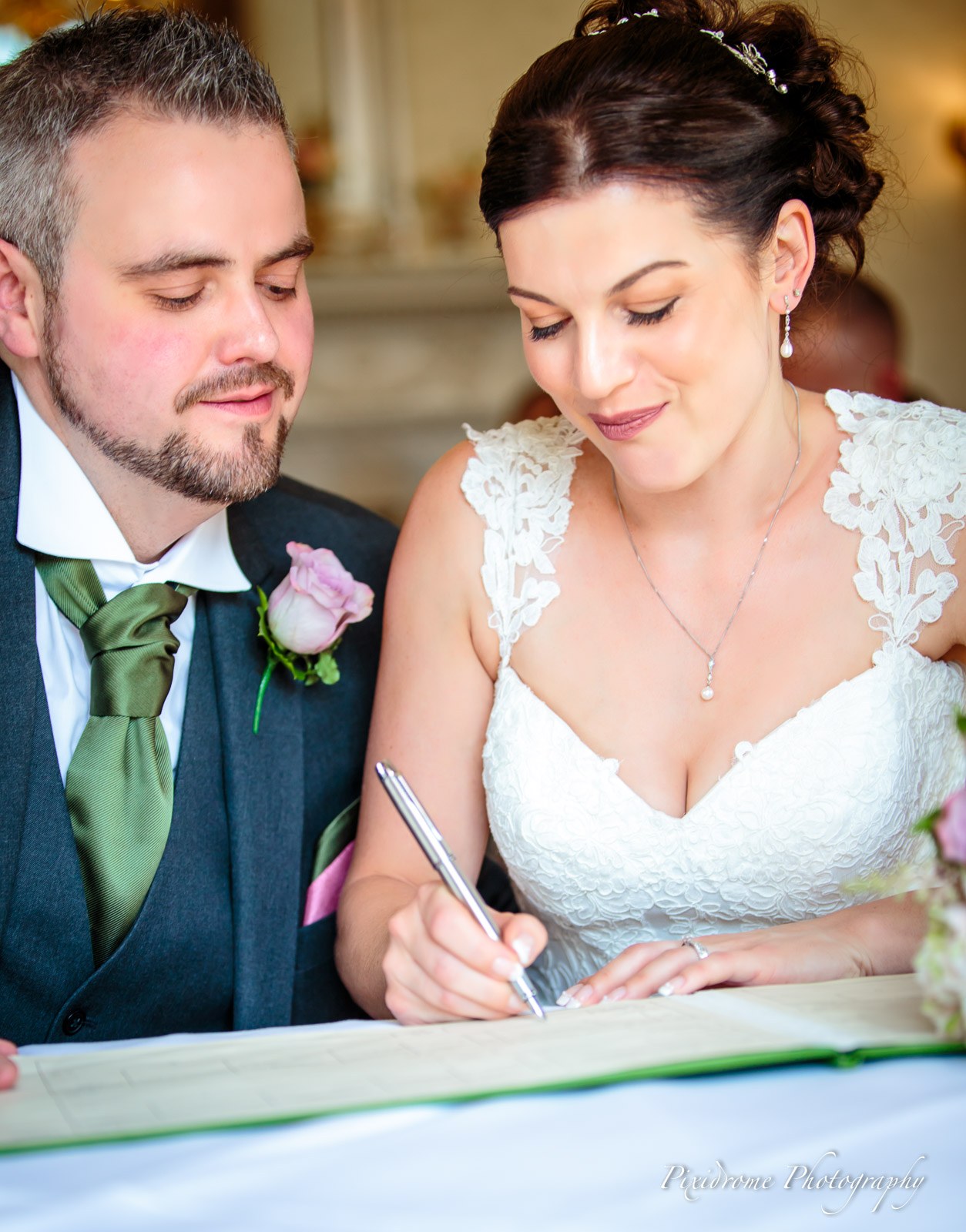 The couple signing the marriage register side by side