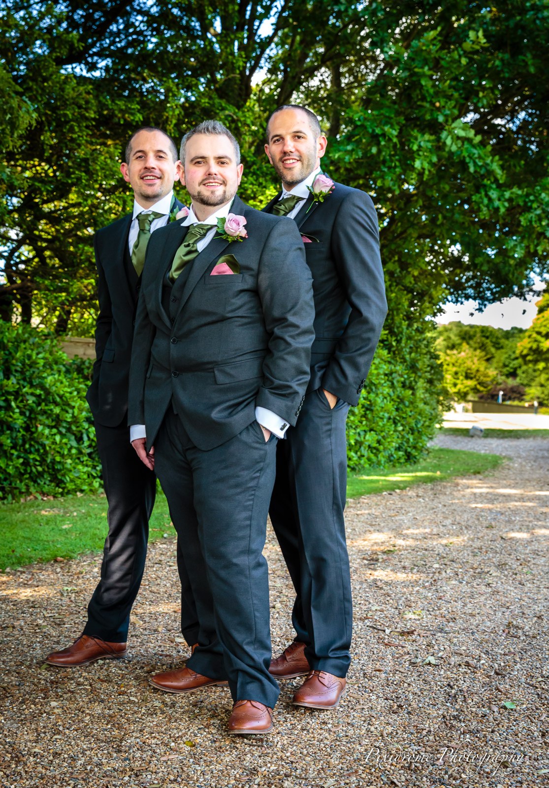 The groom and two groomsmen posed on the gravel path through the grounds of Highfield Park