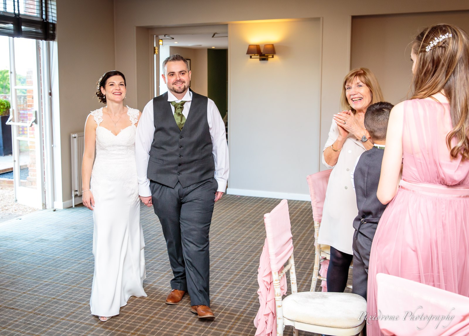 Guests applauding as the newlyweds enter the reception room