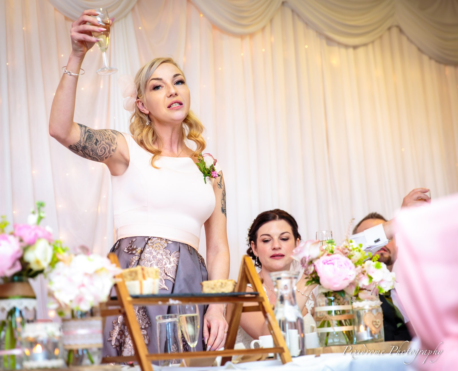 A guest on her feet raising a glass to toast during the speeches
