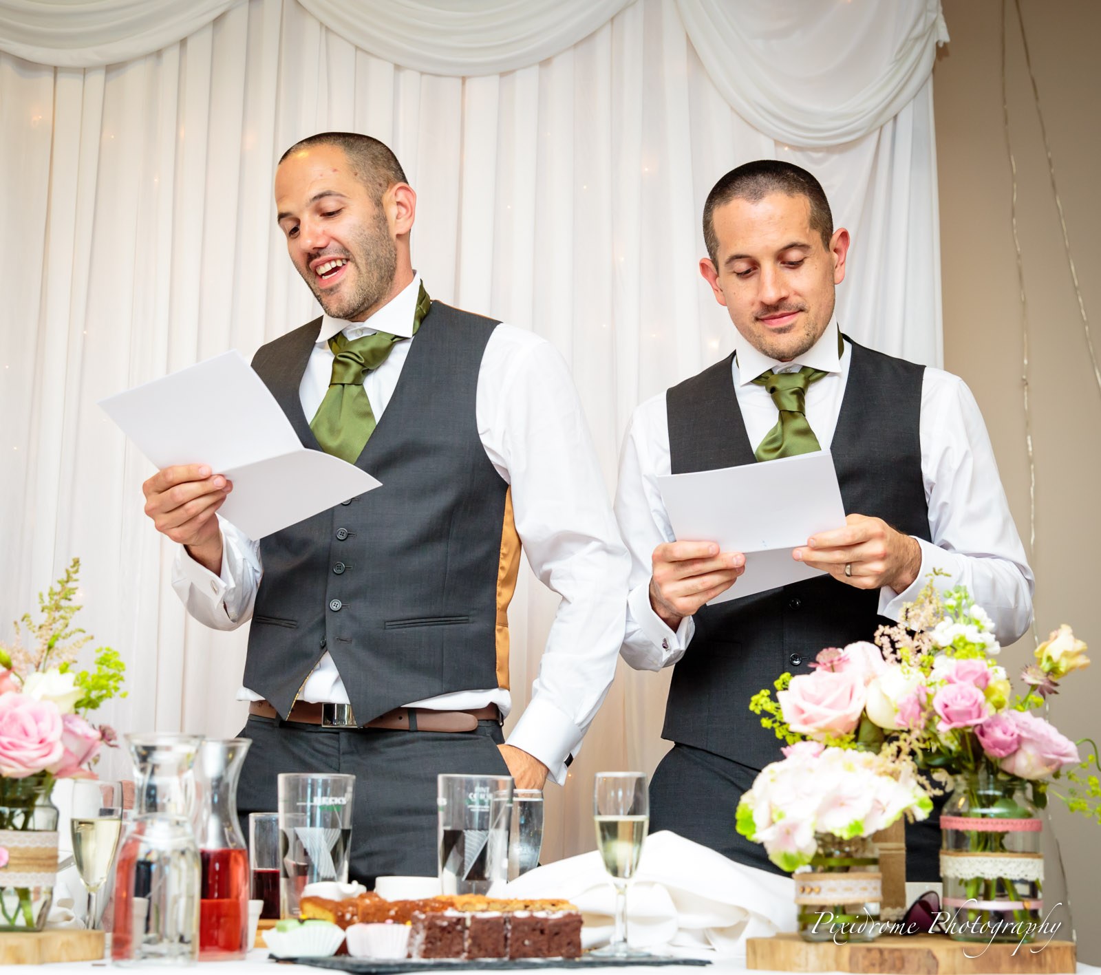 Two best men reading a speech together at the top table