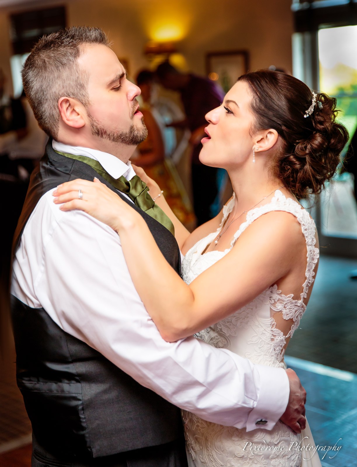 The newlyweds dancing face to face at their first dance