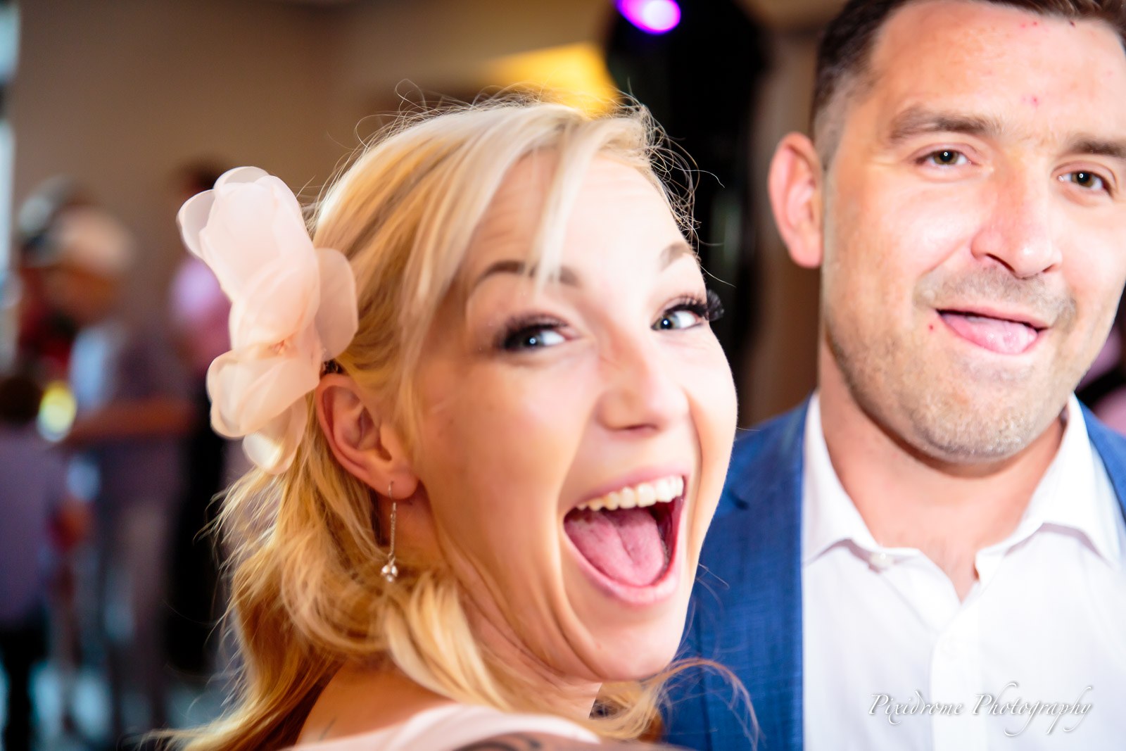 A guest laughing brightly beside a partner during the party
