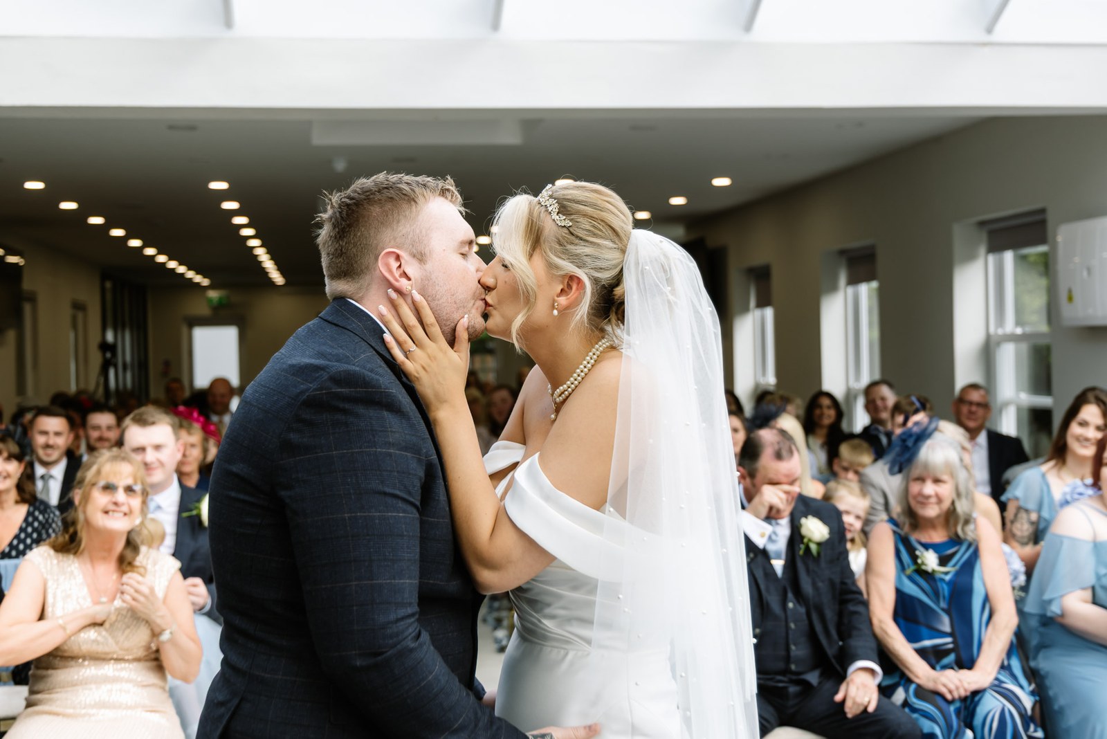 The couple sharing their first kiss as guests look on