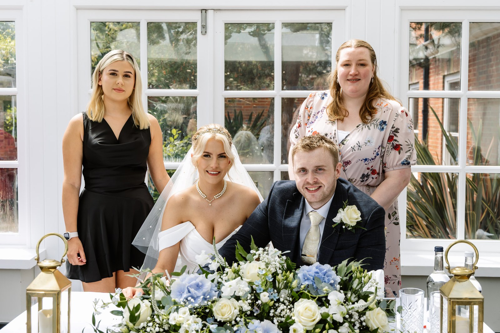 The newlyweds at the register table with their two witnesses, hydrangeas in the foreground