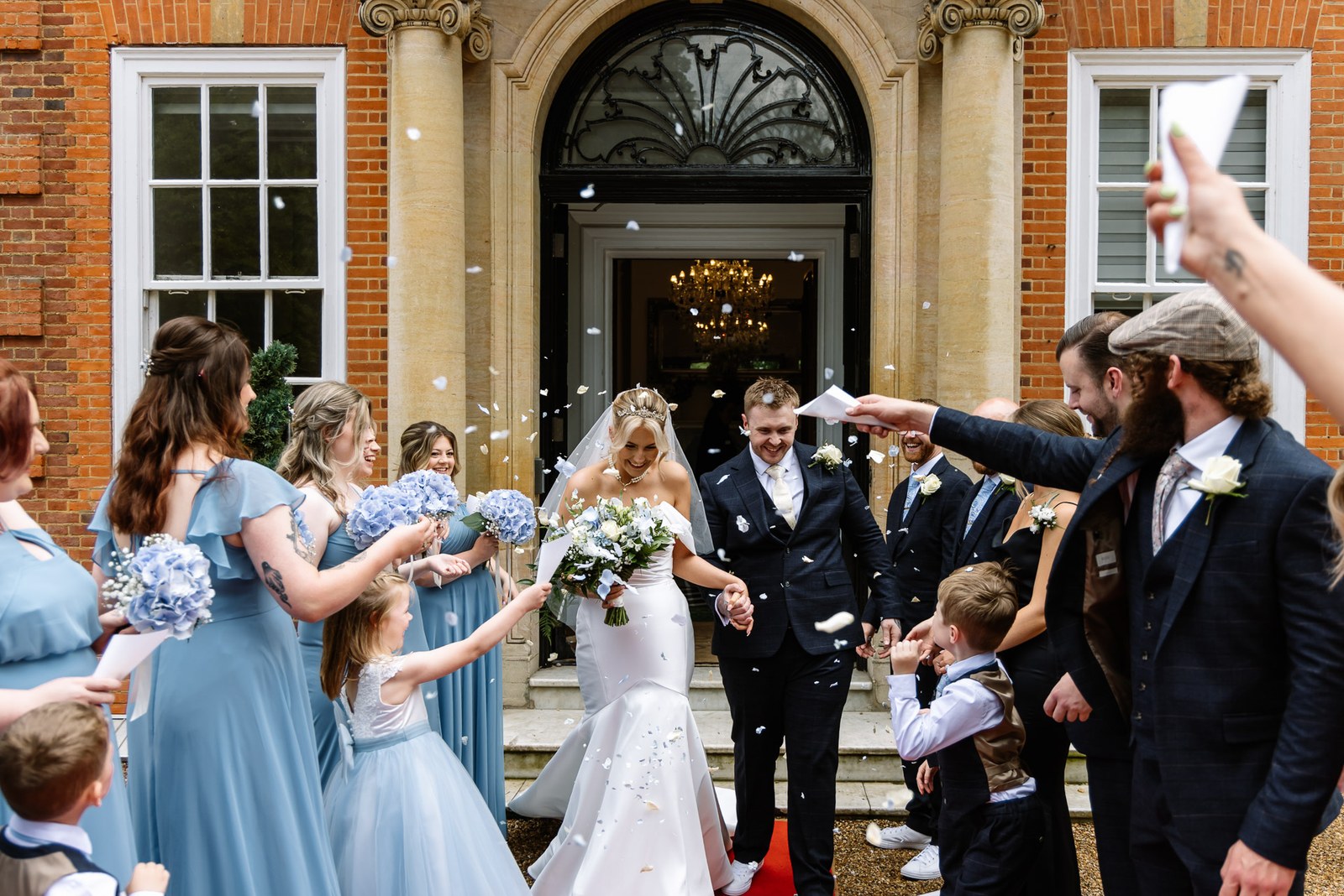 Confetti thrown over the couple in the arched doorway of Hunton Park Hotel