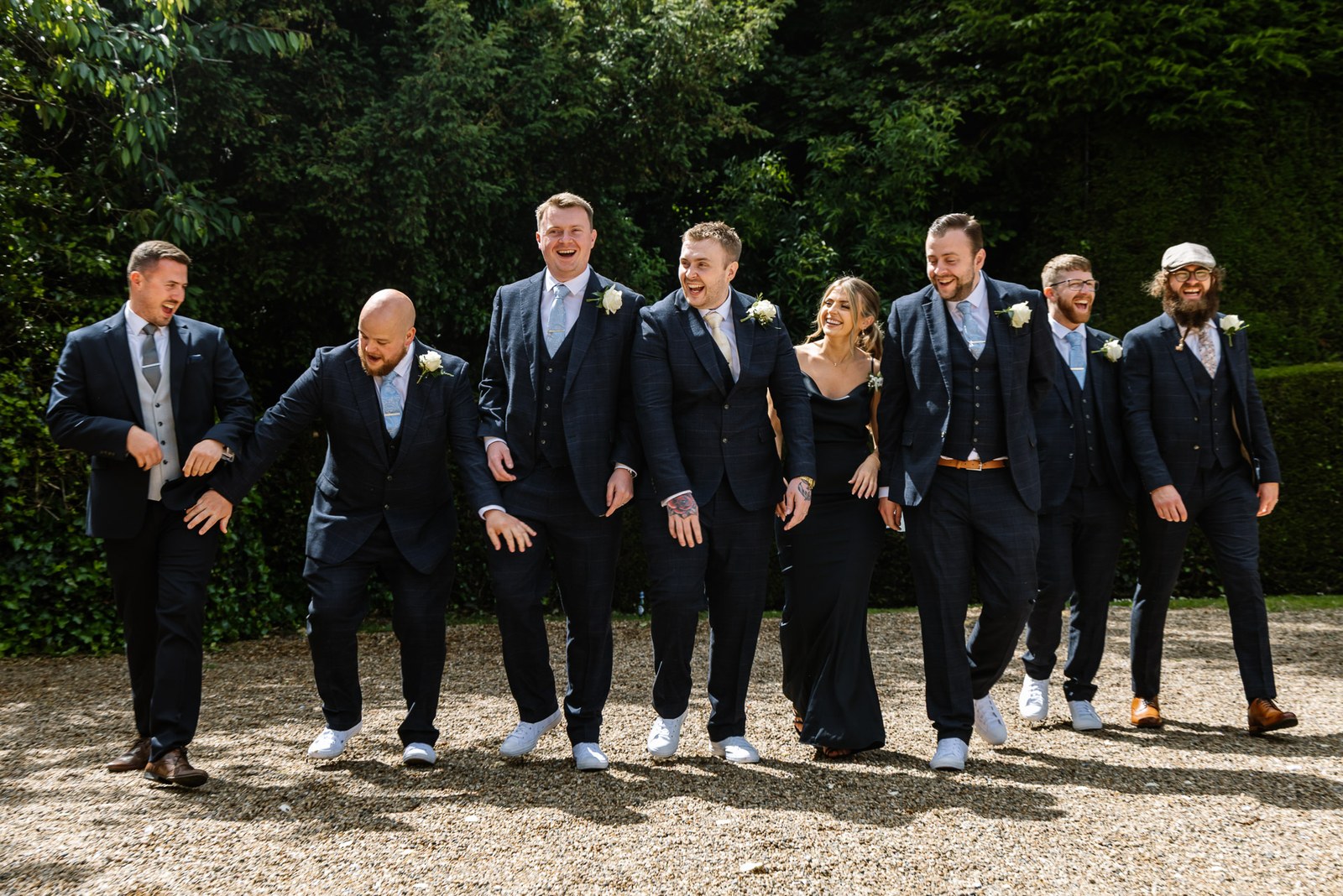 The groomsmen striding along together in a playful line