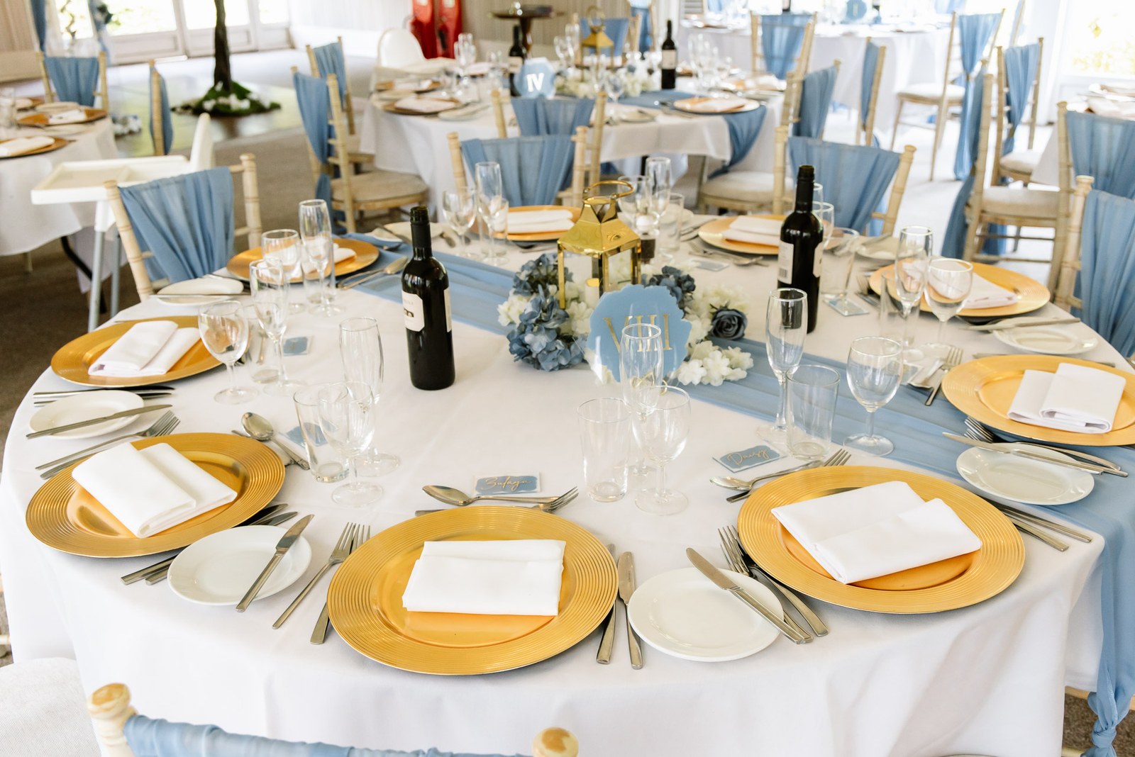 A reception table laid with blue sashes and gold charger plates at Hunton Park Hotel