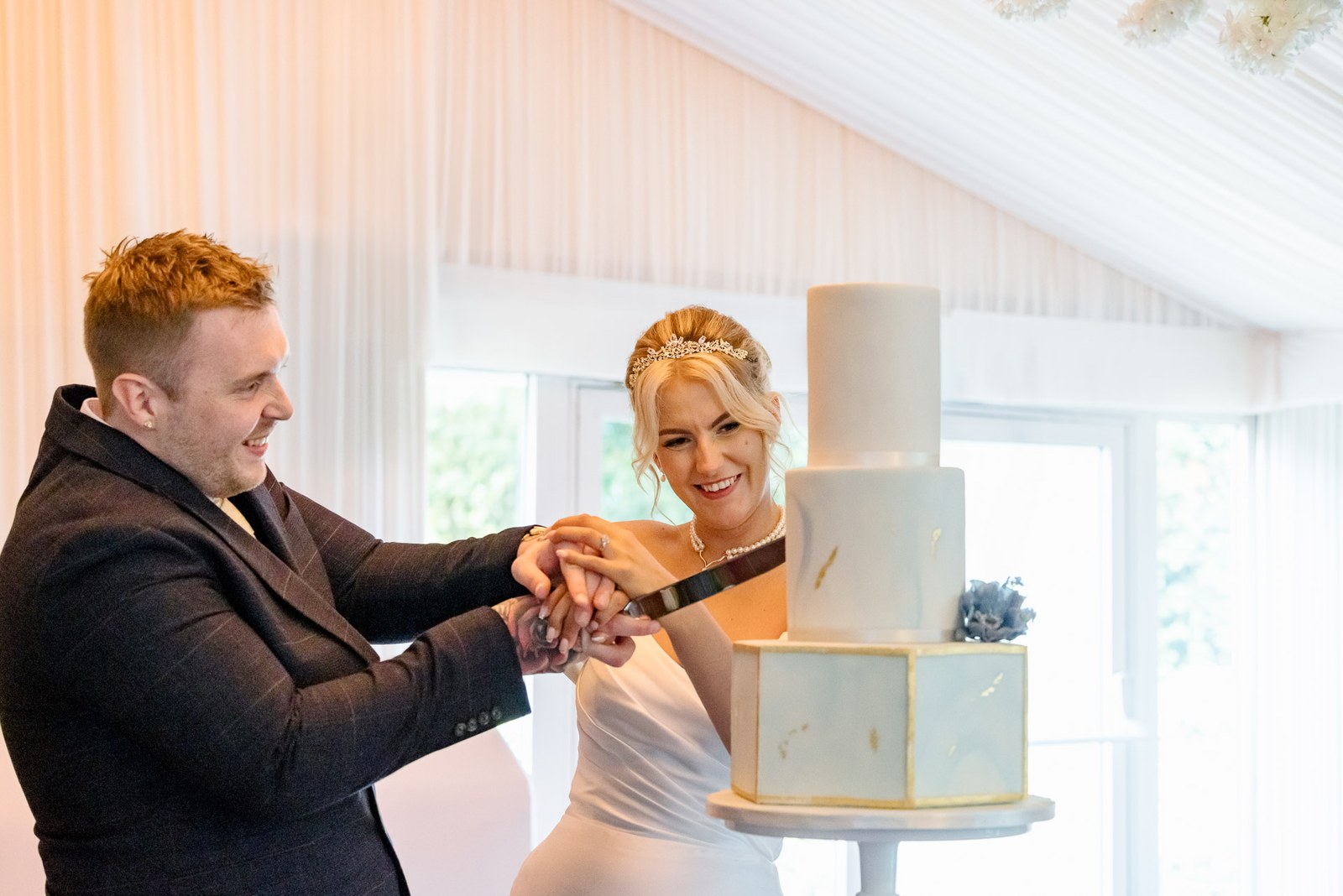 Bride and groom cutting their marble-effect tiered cake