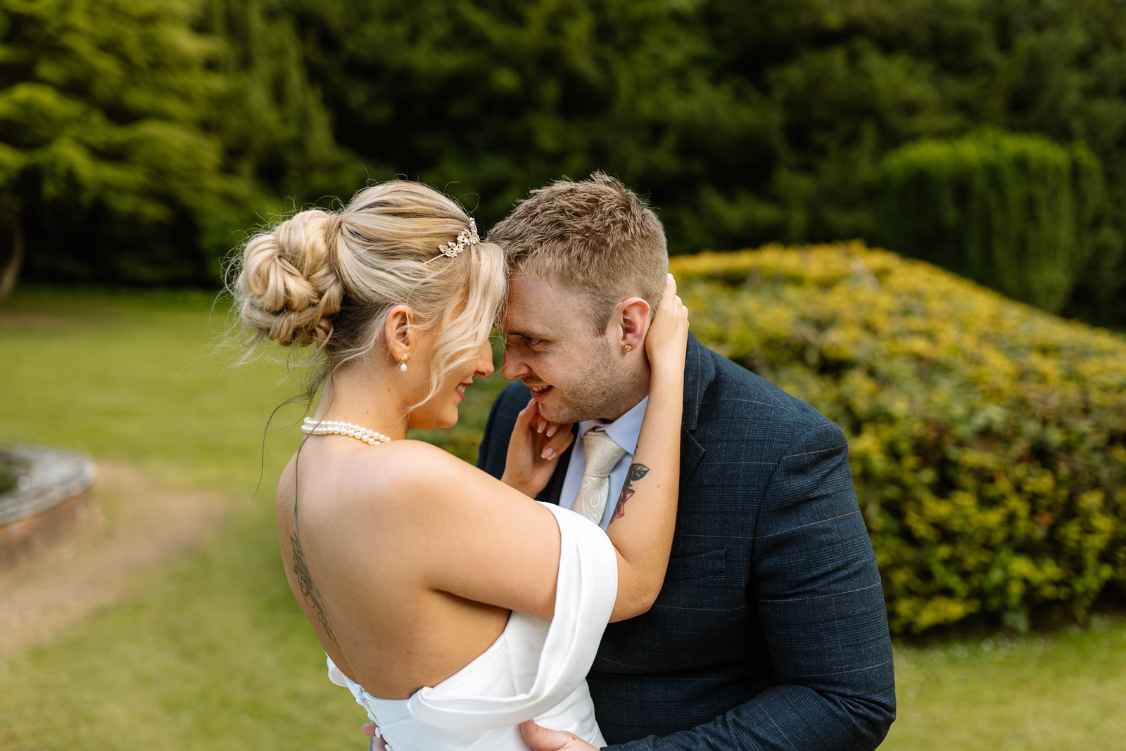 The couple in a close embrace in the formal garden
