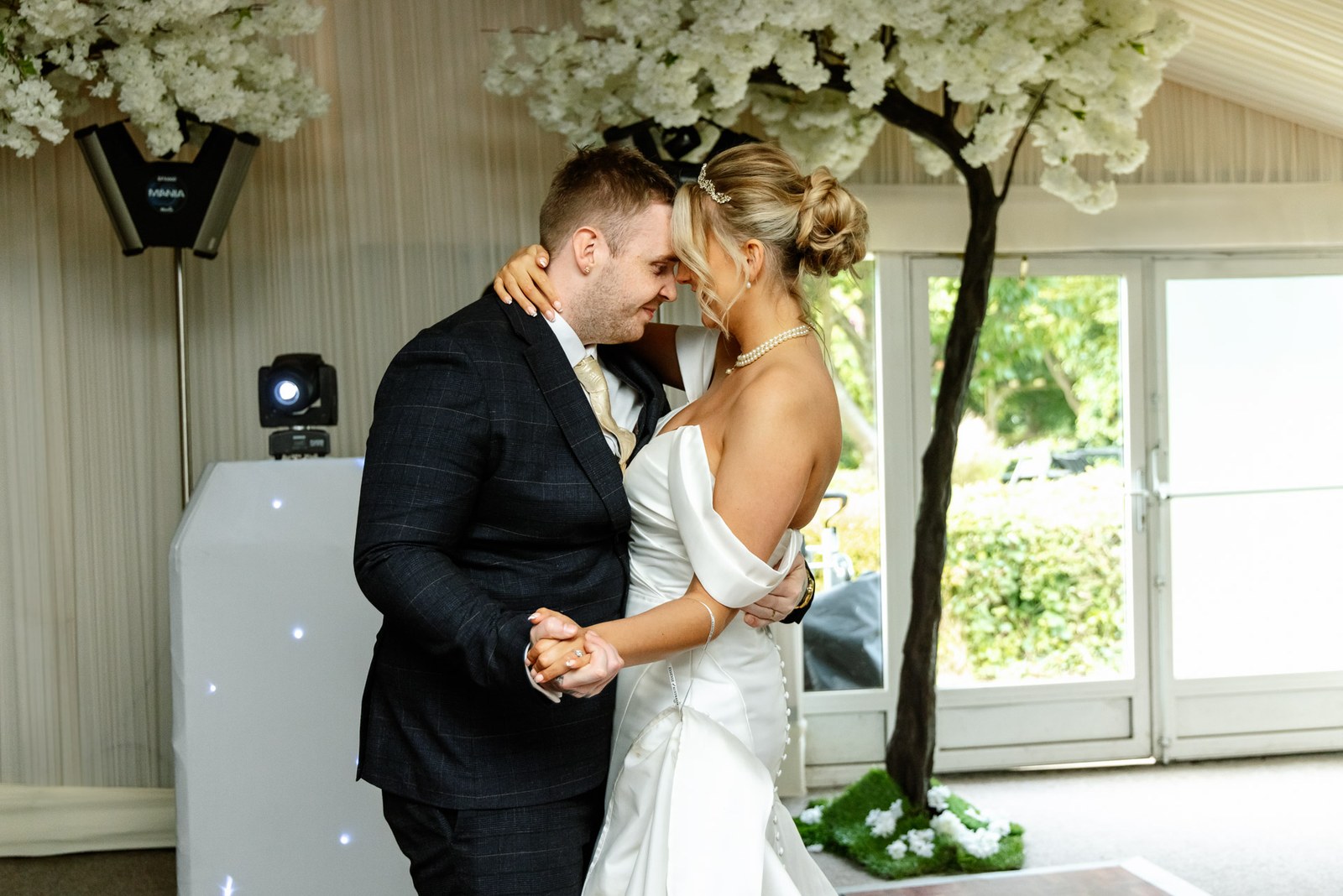 The couple's first dance among the blossom trees and soft lighting